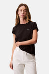 Zwart T-shirt met korte mouwen van Calvin Klein, gedragen met een witte high-waisted jeans.