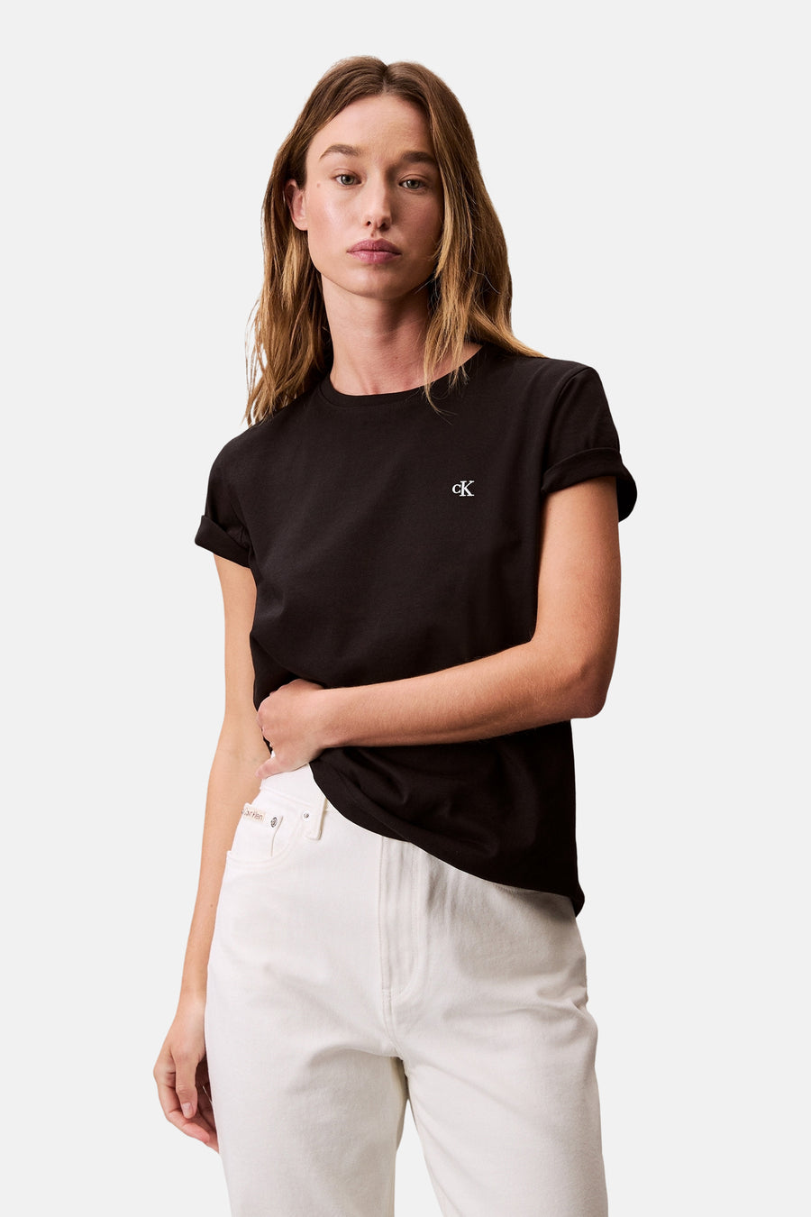 Zwart T-shirt met korte mouwen van Calvin Klein, gedragen met een witte high-waisted jeans.