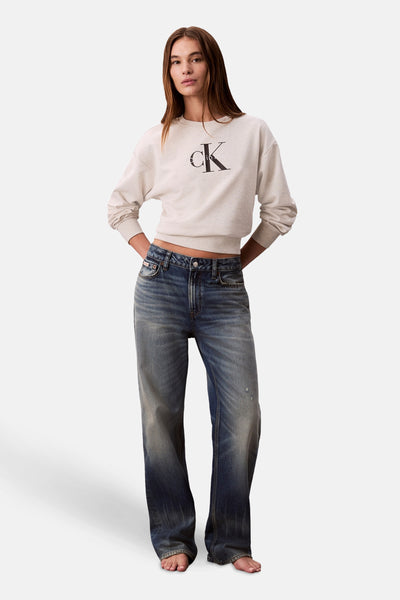 Beige ronde hals sweatshirt van Calvin Klein, gedragen met een wijde, lage spijkerbroek.