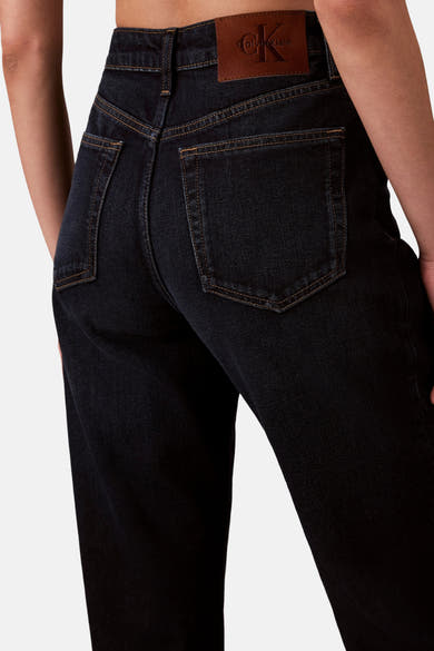 Jean droit en denim bleu foncé de Calvin Klein, avec coutures contrastantes et écusson en cuir.