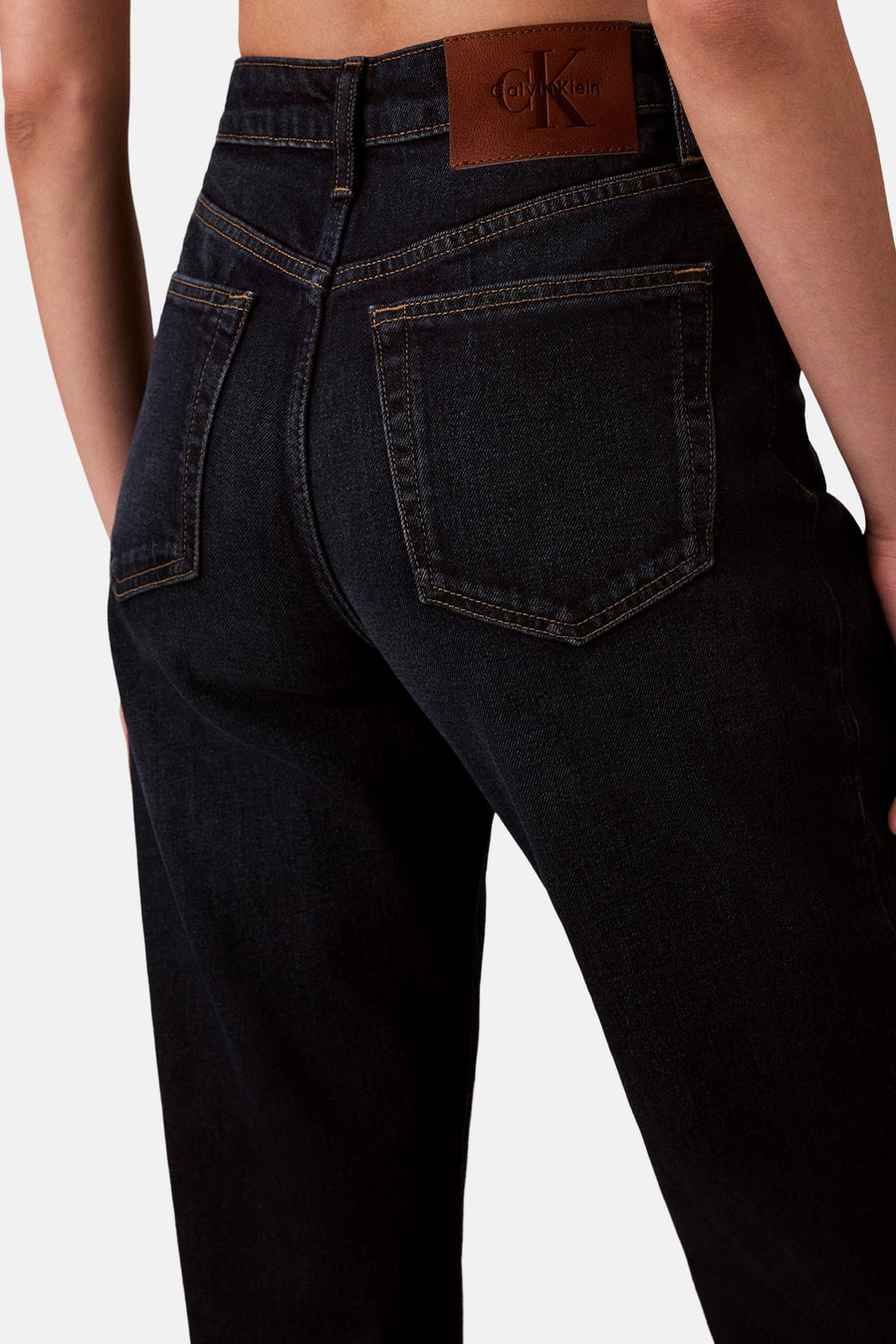 Jean droit en denim bleu foncé de Calvin Klein, avec coutures contrastantes et écusson en cuir.
