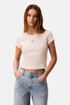 Ecru T-shirt met korte mouwen van Calvin Klein, gedragen met een lichtblauwe jeans met hoge taille.