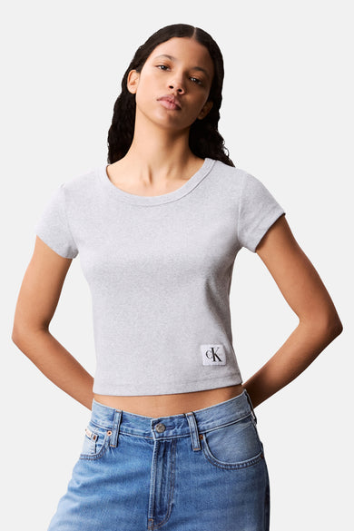 T-shirt gris à manches courtes de Calvin Klein, en maille côtelée, porté avec un jean taille basse.