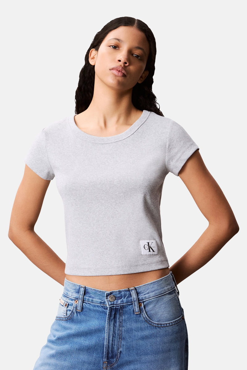 T-shirt gris à manches courtes de Calvin Klein, en maille côtelée, porté avec un jean taille basse.