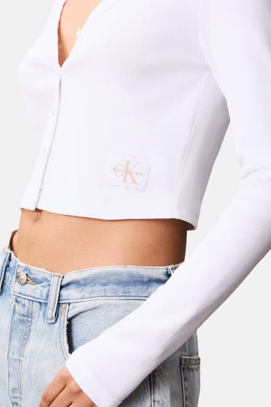 Wit T-shirt met lange mouwen van Calvin Klein, in geribbelde stof, gedragen met een jeans met hoge taille.