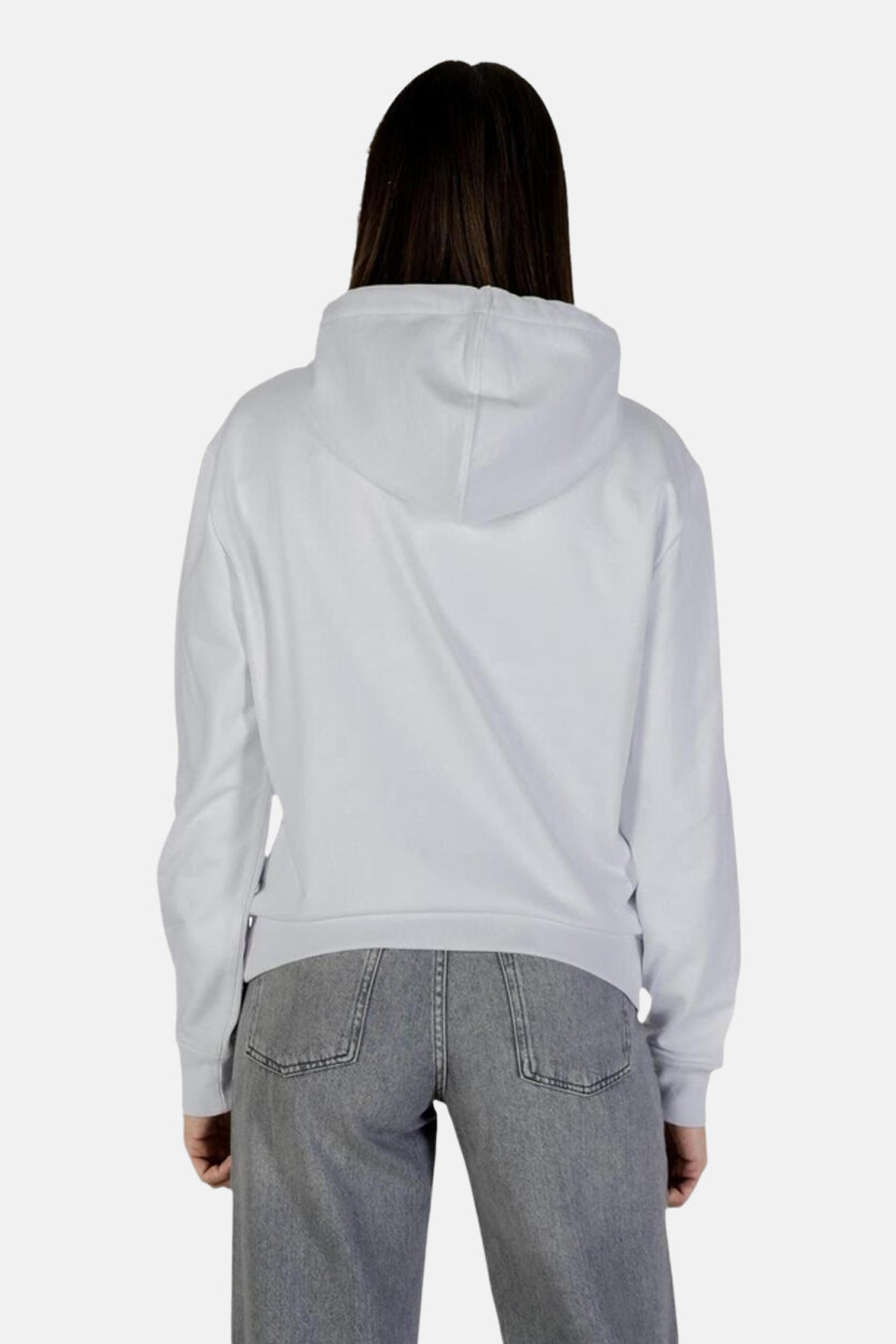 Sweat à capuche blanc de Calvin Klein, porté avec un jean gris, vue de dos.