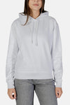 Sweat à capuche blanc de Calvin Klein, avec cordon de serrage et logo discret sur le devant, porté avec un jean gris.
