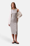 Robe grise de Calvin Klein avec chemise ouverte crème et sandales noires.