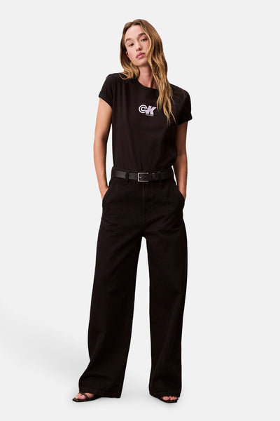 T-shirt noir à manches courtes de Calvin Klein, porté avec un pantalon noir large et une ceinture noire.