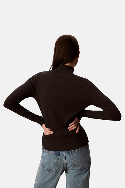 Zwart T-shirt met lange mouwen van Calvin Klein, gedragen met een high-waisted jeans, achtergezicht.