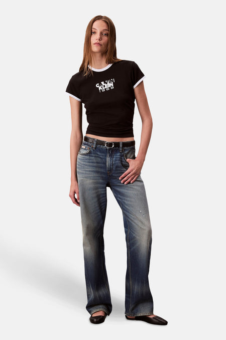 Top met korte mouwen zwart van Calvin Klein met witte kraag en mouwen, gedragen met een verbleekte spijkerbroek en zwarte schoenen.