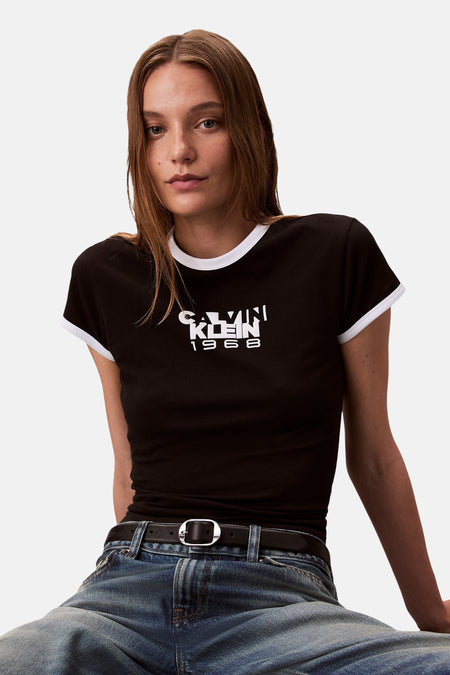 Top met korte mouwen zwart van Calvin Klein met mouwen met witte bies, gedragen met een spijkerbroek en een zwarte riem.