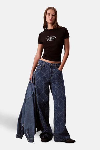 Zwart T-shirt met korte mouwen van Calvin Klein met wit logo, gedragen met een blauwe spijkerbroek met ruitpatroon.