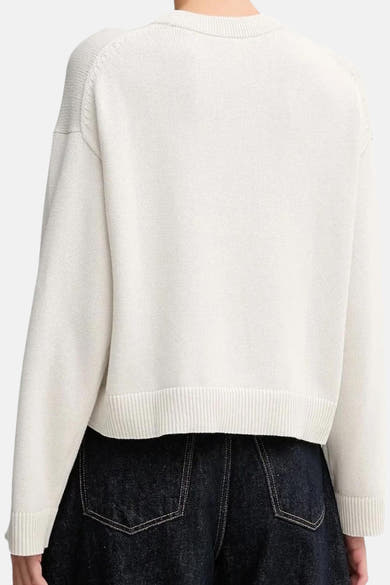Beige ronde hals sweatshirt van Calvin Klein, met lange mouwen en geribbelde zoom, gedragen met een donkere spijkerbroek.