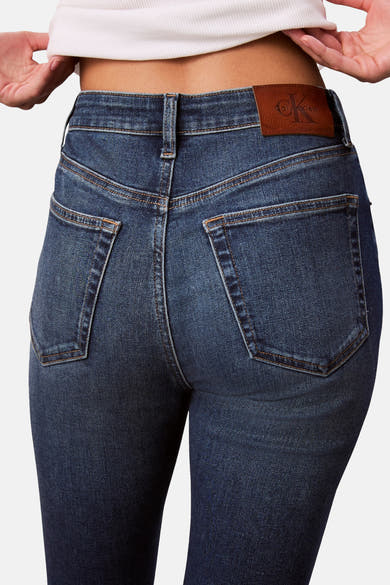 Jean skinny en denim bleu moyen de Calvin Klein, avec poches arrière et patch logo en cuir.
