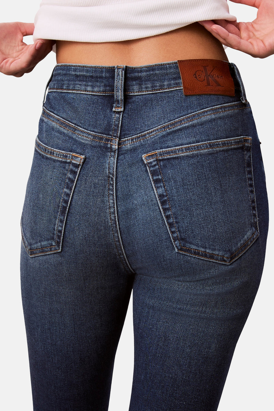 Jean skinny en denim bleu moyen de Calvin Klein, avec poches arrière et patch logo en cuir.
