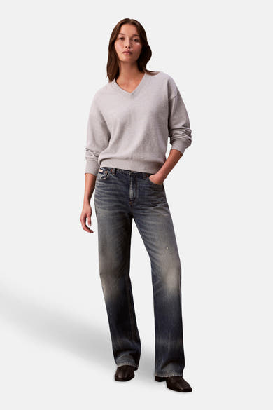 Sweat gris de Calvin Klein, porté avec un jean délavé et des chaussures noires.