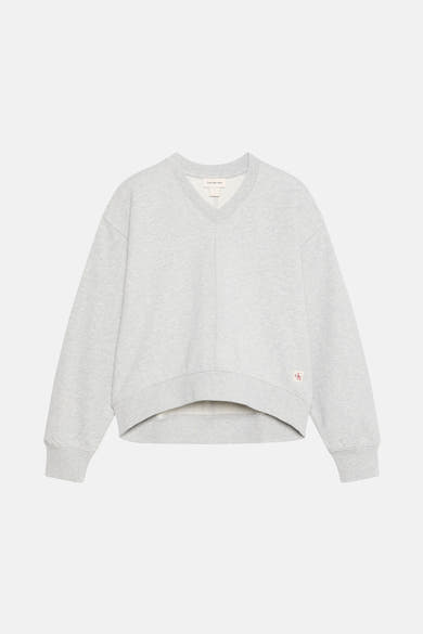 Sweat gris chiné de Calvin Klein Jeans avec un col en V et un logo rouge brodé sur le côté.
