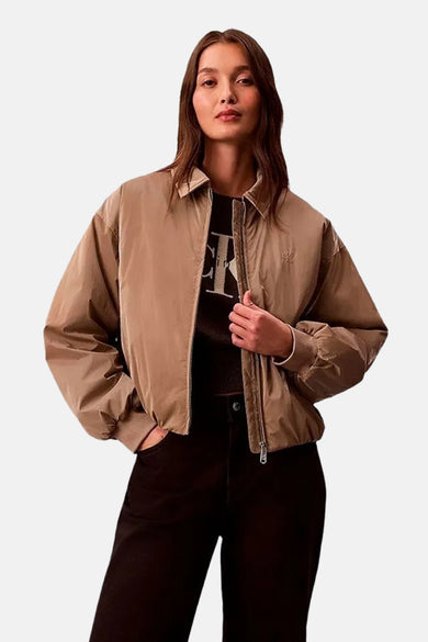 Veste courte beige de Calvin Klein, légère, avec fermeture éclair, logo brodé sur la poitrine et poignets côtelés.