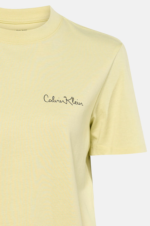 T-shirt jaune à manches courtes de Calvin Klein, avec logo manuscrit noir sur la poitrine.