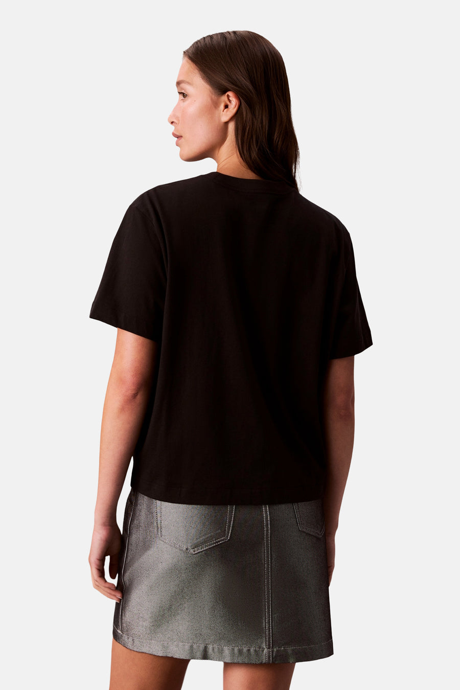 Zwart T-shirt met korte mouwen van Calvin Klein, gedragen met een grijze textuurrok.