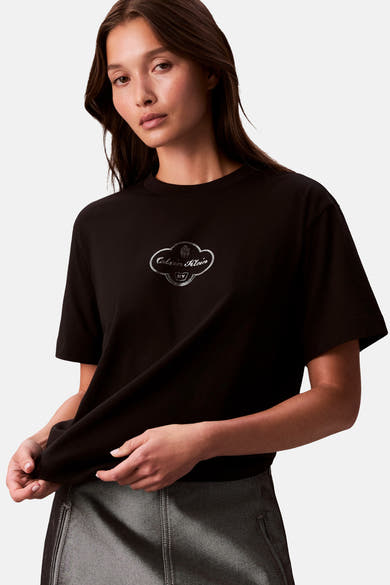 Zwart T-shirt met korte mouwen van Calvin Klein, met decoratief logo op de borst en gedragen met een grijze rok.