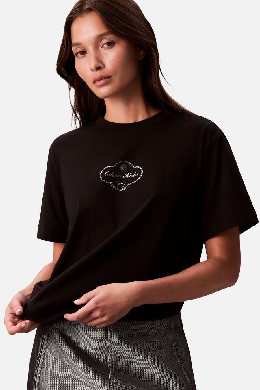 Zwart T-shirt met korte mouwen van Calvin Klein, met decoratief logo op de borst en gedragen met een grijze rok.