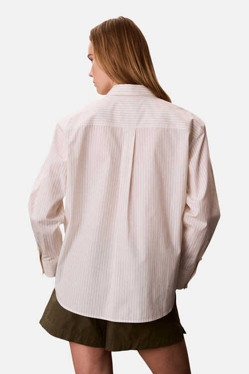 Chemise à manches longues beige rayée de Calvin Klein, vue de dos, avec pli creux et manches boutonnées.
