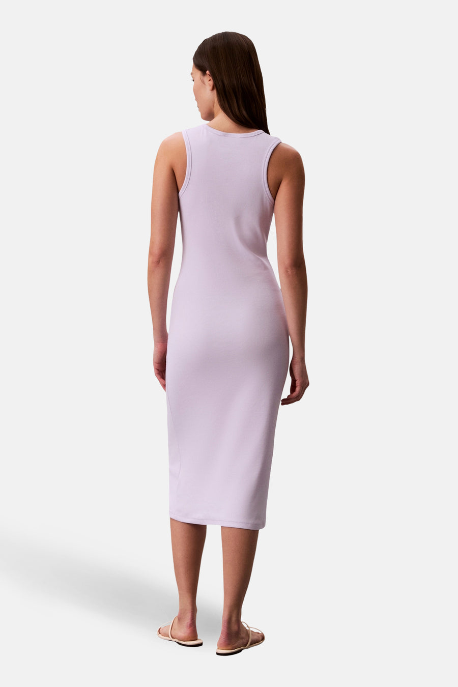 Mouwloze, halflange, paarse jurk van Calvin Klein, van achteren gezien, gedragen met neutrale sandalen.
