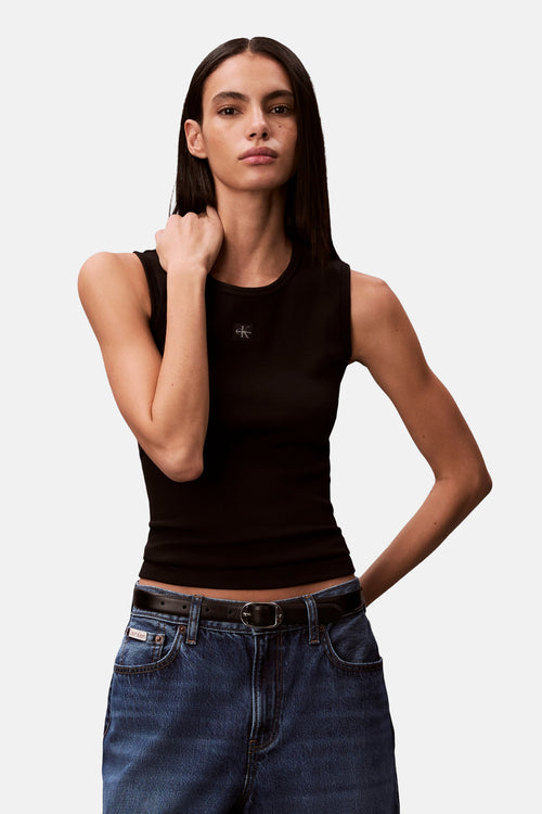 Débardeur noir de Calvin Klein, porté avec un jean taille haute et une ceinture en cuir noire.

