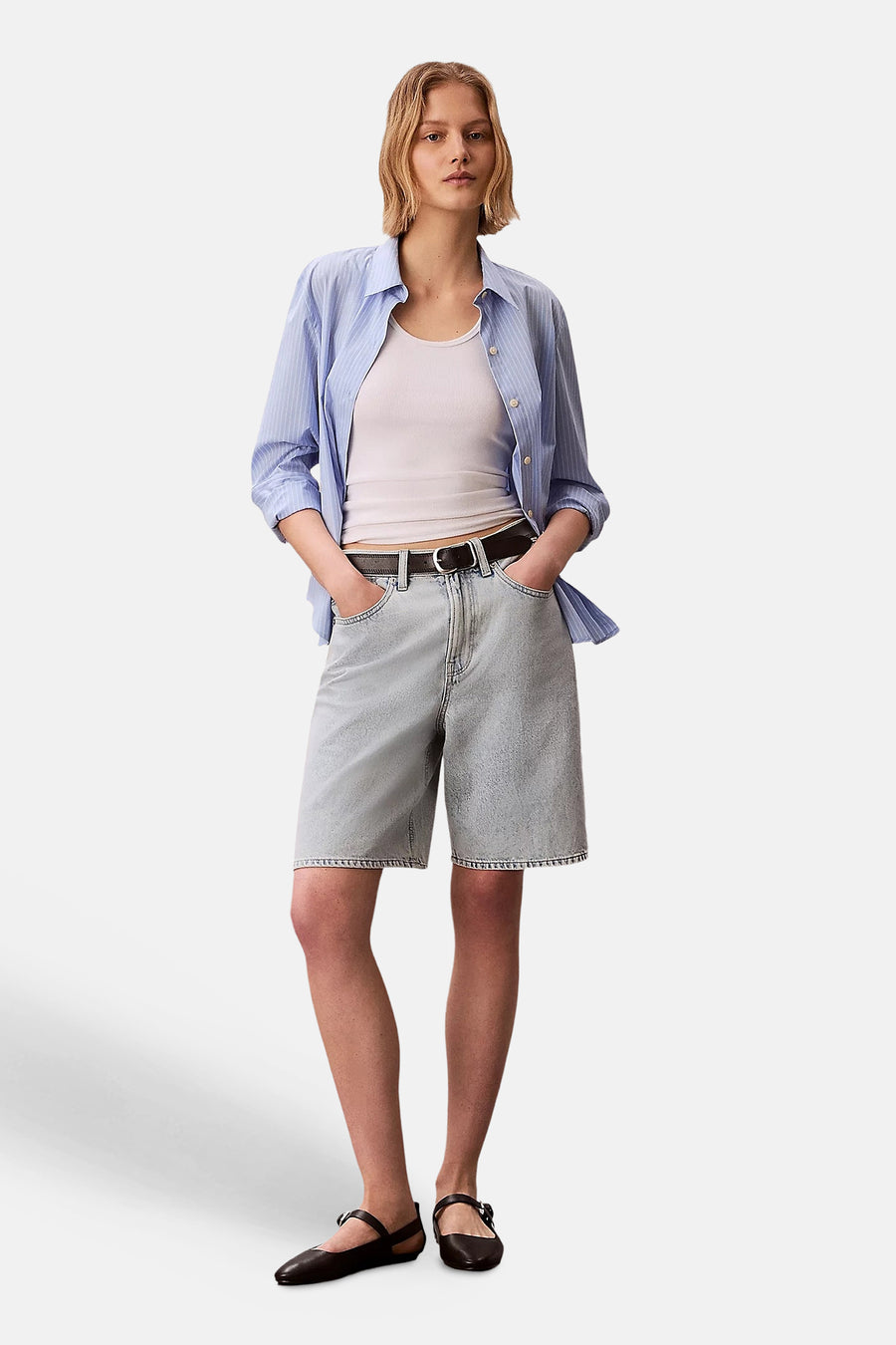 Short en denim bleu clair de Calvin Klein, porté avec une chemise rayée bleue et blanche.