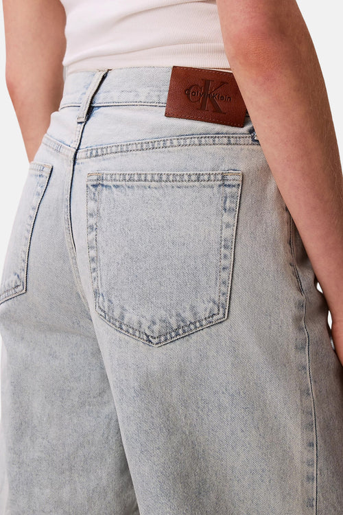 Short en denim bleu clair de Calvin Klein, avec poche arrière et étiquette en cuir marron.
