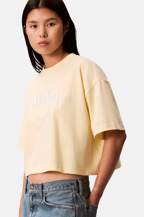 T-shirt jaune à manches courtes de Calvin Klein, porté avec un jean taille haute.
