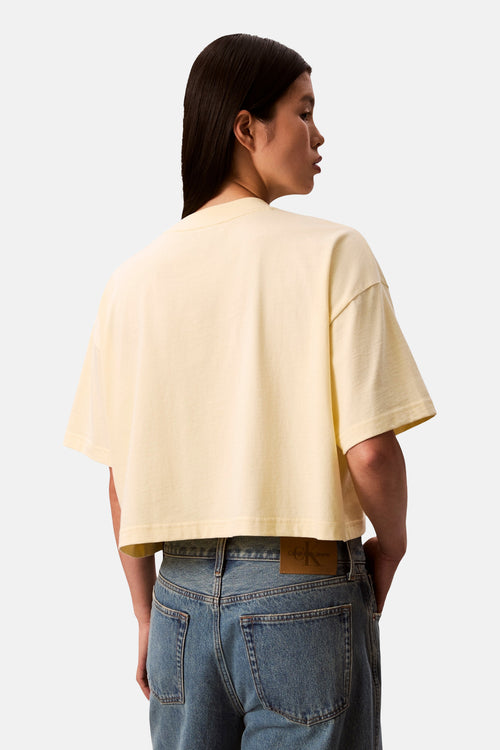 T-shirt jaune uni à manches courtes de Calvin Klein, détail du dos et porté avec un jean.
