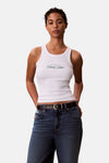 Witte tanktop van Calvin Klein, in geribbelde jersey, gedragen met een high-waisted jeans en een zwarte riem.