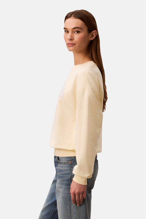 Sweat-shirt jaune de Calvin Klein avec un logo brodé discret sur le devant, porté avec un jean.