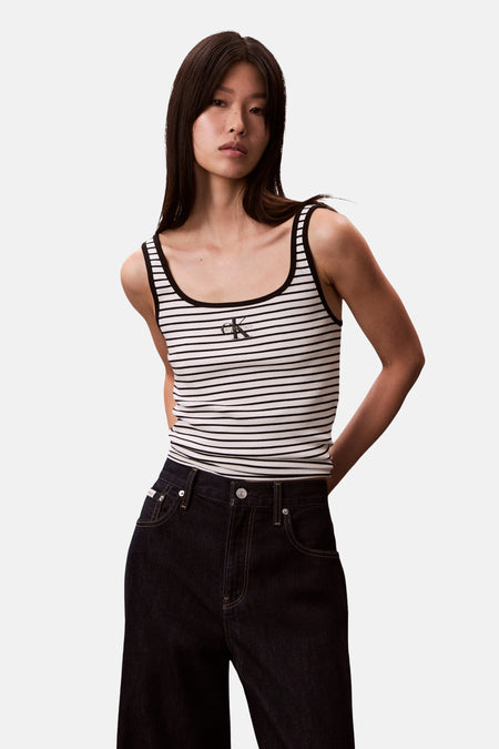 Débardeur rayé multicolore de Calvin Klein, porté avec un jean taille haute indigo.
