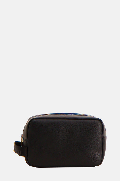 Trousse de toilette noire en cuir par Calvin Klein, avec logo CK discret en bas.