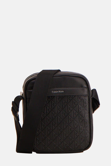 Zwarte Calvin Klein schoudertas met reliëf monogrampatroon in getextureerd leer.