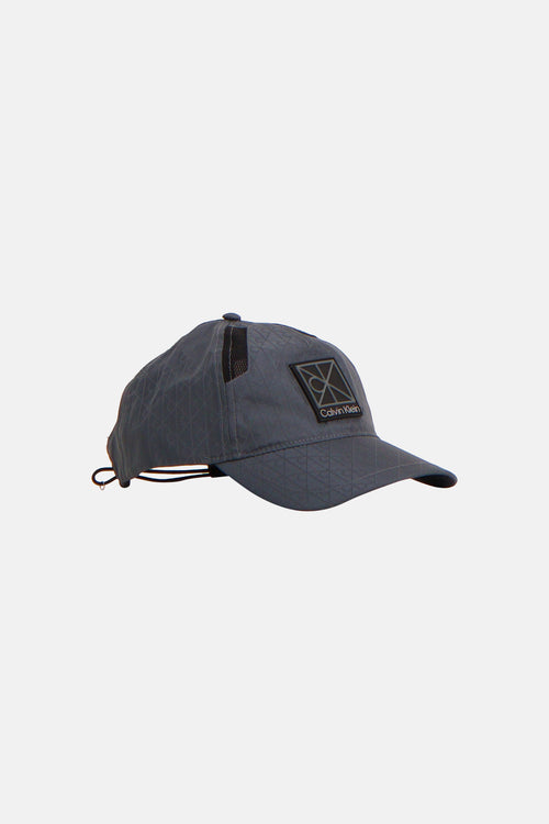 Casquette bleue de Calvin Klein, avec un motif imprimé subtil et une étiquette logo carrée.