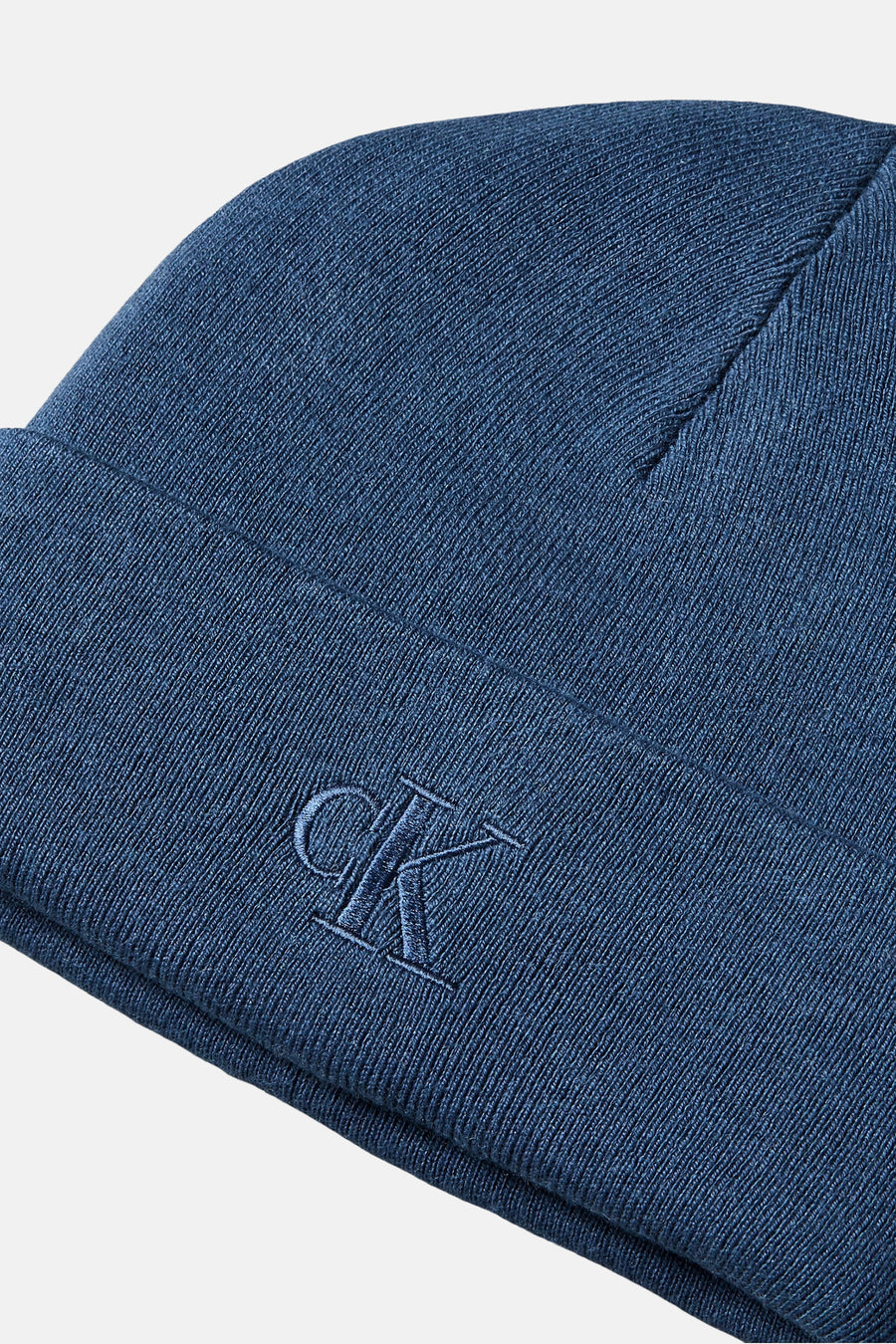 Bonnet bleu par Calvin Klein, avec logo CK brodé sur le devant et texture tricotée.
