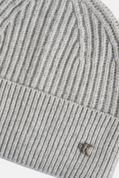 Bonnet gris en tricot de Calvin Klein, motif côtelé avec un logo métallique.