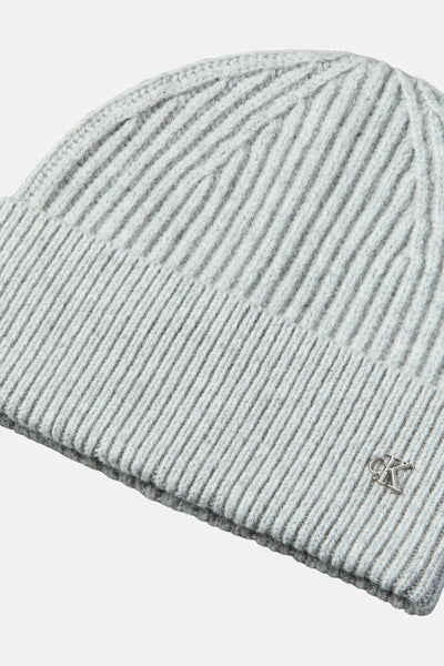 Bonnet gris côtelé de Calvin Klein, avec un logo métallique discret.
