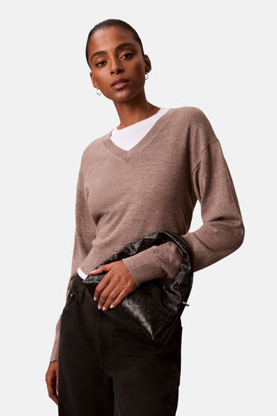 Zwarte Calvin Klein schoudertas met gewatteerd patroon, gedragen met een zwarte jeans.