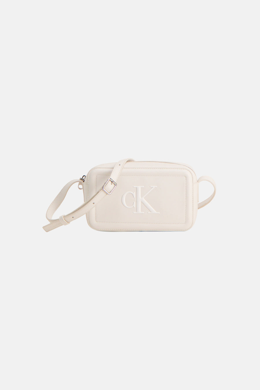 Witte Calvin Klein schoudertas, gedragen met een zwarte broek en bijpassende pumps, in zijaanzicht.