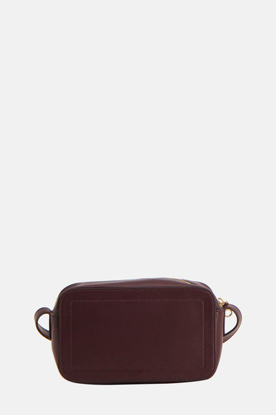 Sac à bandoulière bordeaux de Calvin Klein avec une fermeture éclair dorée sur le dessus.
