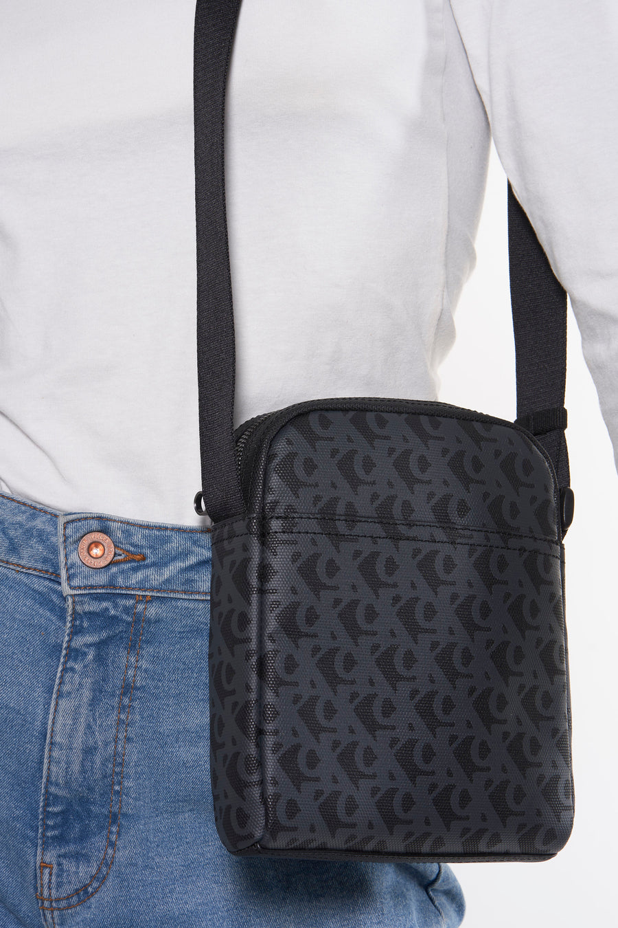 Grijze Calvin Klein schoudertas met logoprint, gedragen met een spijkerbroek en een wit T-shirt.