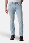 Jean slim en denim bleu clair de Calvin Klein, avec des chaussures noires.