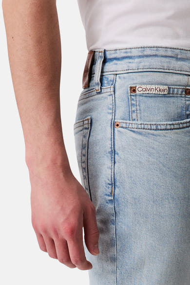 Jean slim en denim bleu clair de Calvin Klein avec poche arrière portant le logo de la marque.