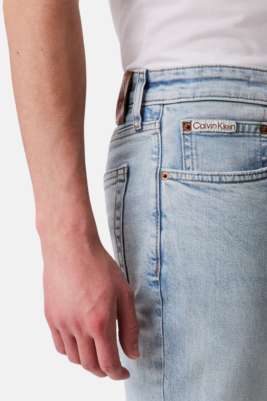 Jean slim en denim bleu clair de Calvin Klein avec poche arrière portant le logo de la marque.